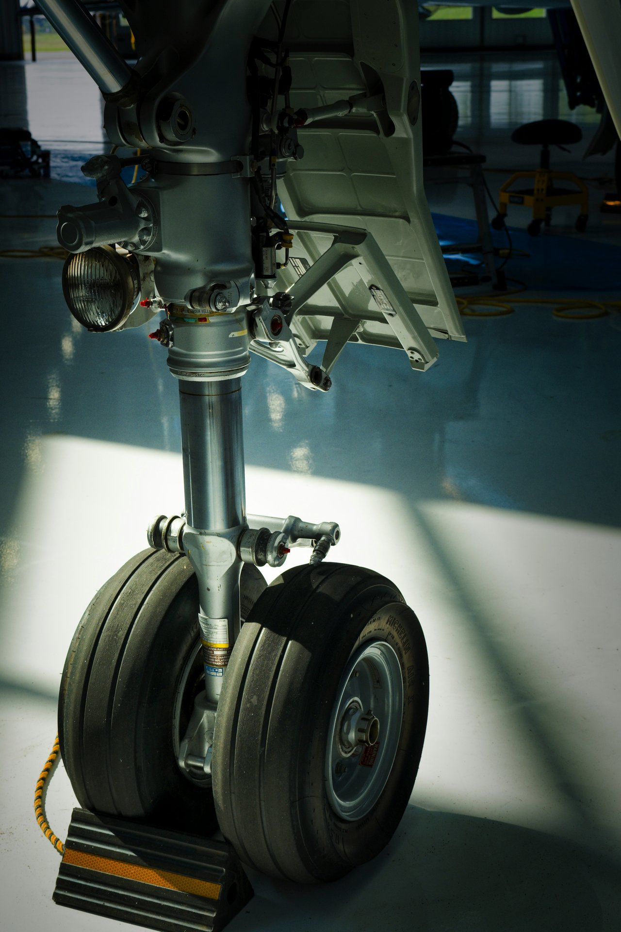 Aircraft landing gear close-up showing wheel bogie and hydraulic actuators